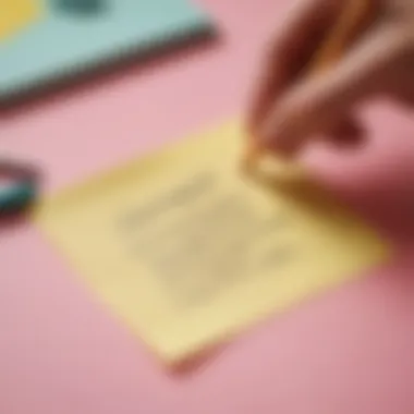 A close-up of a hand writing a motivational message on a sticky note